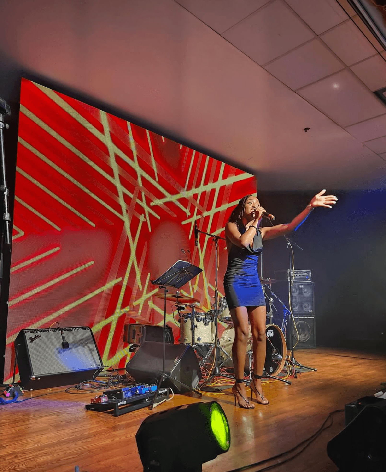 Live performance on stage with artist performing under event structure with Canadian flag